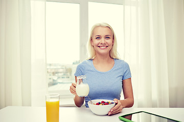 Image showing woman with milk and cornflakes eating breakfast