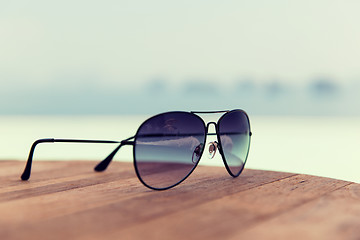 Image showing shades or sunglasses on table at beach