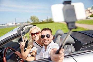 Image showing happy couple in car taking selfie with smartphone