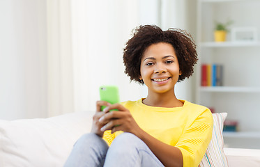 Image showing happy african woman with smartphone at home