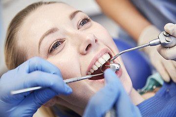 Image showing close up of dentist treating female patient teeth