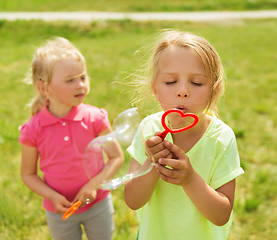 Image showing group of kids blowing soap bubbles outdoors