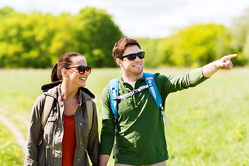 Image showing happy couple with backpacks hiking outdoors