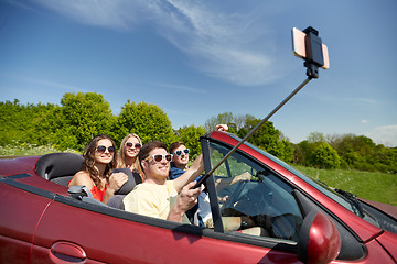 Image showing friends driving in cabriolet car and taking selfie