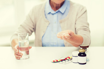 Image showing close up of senior woman with water and pills