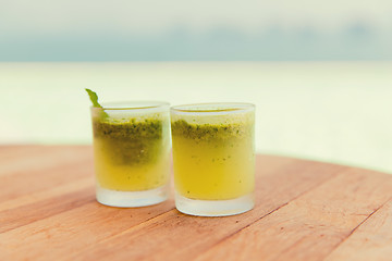 Image showing glasses of fresh juice or cocktail on beach