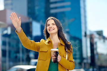 Image showing happy young woman drinking coffee on city street