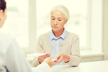 Image showing doctor giving prescription and drug to woman 