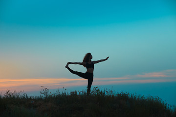 Image showing The silhouette of young woman is practicing yoga