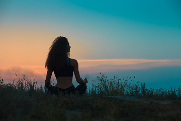 Image showing The silhouette of young woman is practicing yoga