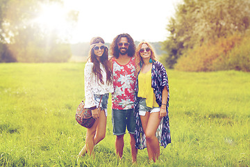 Image showing smiling young hippie friends on green field