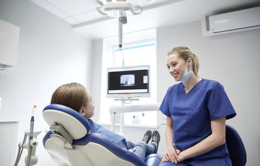 Image showing happy female dentist with patient girl at clinic