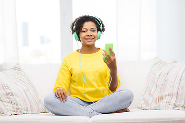 Image showing happy african woman with smartphone and headphones