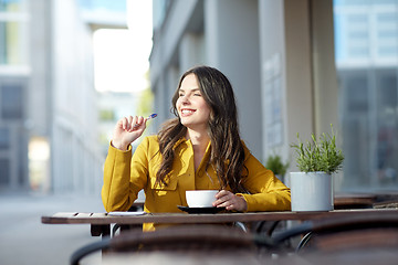 Image showing happy woman with notebook drinking cocoa at cafe