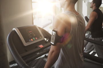 Image showing smiling men exercising on treadmill in gym
