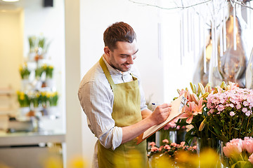 Image showing florist man with clipboard at flower shop