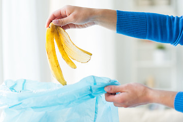 Image showing close up of hand putting food waste to rubbish bag