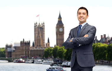 Image showing happy smiling businessman in suit over london city