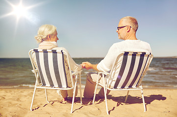 Image showing happy senior couple in chairs on summer beach