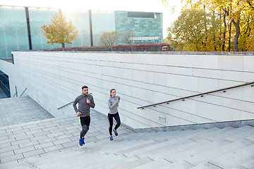 Image showing happy couple running upstairs on city stairs