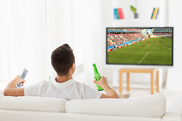 Image showing man watching soccer game on tv and drinking beer