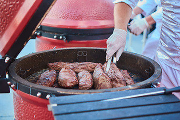 Image showing thick strip steak being grilled outdoors. Shallow dof