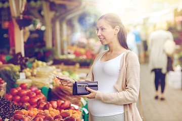 Image showing pregnant woman with wallet buying food at market