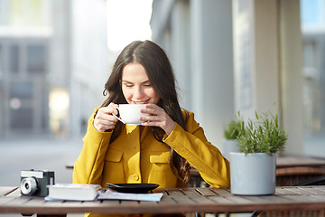Image showing happy tourist woman drinking cocoa at city cafe