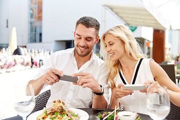 Image showing happy couple with smatphone photographing food