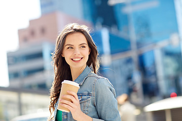 Image showing happy young woman drinking coffee on city street