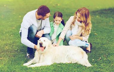 Image showing happy family with labrador retriever dog in park