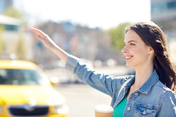 Image showing happy young woman drinking coffee on city street