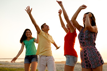 Image showing smiling friends dancing on summer beach