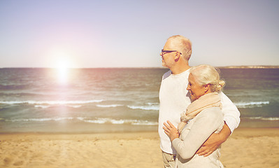 Image showing happy senior couple walking along summer beach
