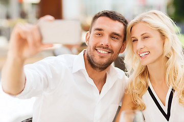 Image showing happy couple taking selfie with smatphone outdoors