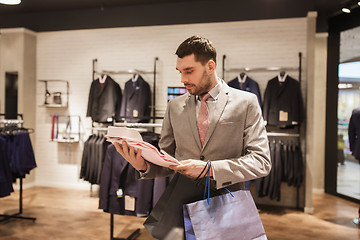 Image showing man with shopping bags and shirt in clothing store