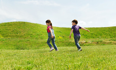 Image showing happy little boy and girl running outdoors