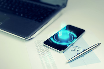 Image showing close up of smartphone, laptop and pen on table