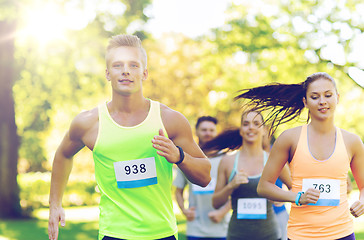 Image showing happ young sportsmen racing wit badge numbers