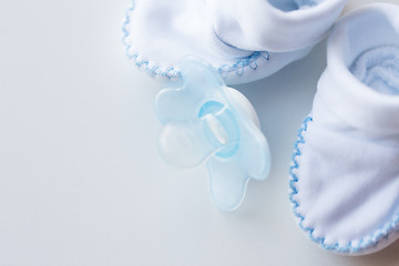 Image showing close up of baby bootees and soother for newborn