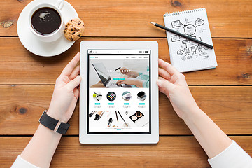 Image showing close up of woman with tablet pc on wooden table