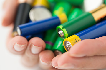 Image showing close up of hands holding alkaline batteries heap