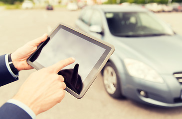 Image showing close up of young man with tablet pc and car