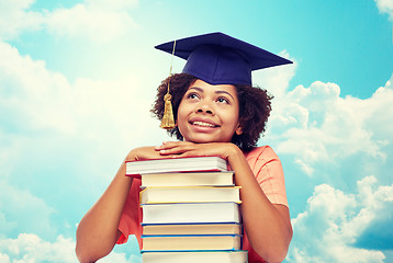 Image showing happy african bachelor girl with books over sky