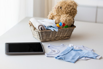 Image showing close up of baby clothes, toys and tablet pc