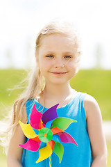 Image showing happy little girl with colorful pinwheel at summer