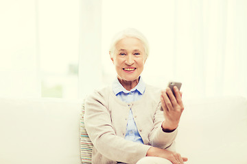 Image showing senior woman with smartphone at home