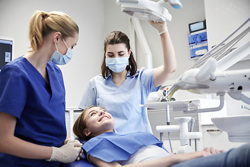 Image showing happy female dentist with patient girl at clinic