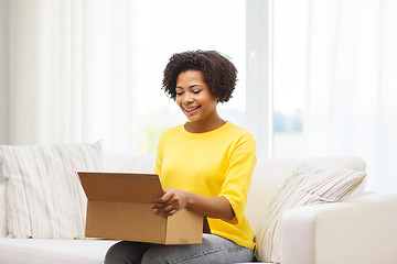 Image showing happy african young woman with parcel box at home