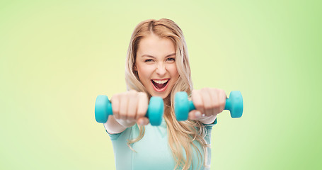 Image showing smiling beautiful young sporty woman with dumbbell